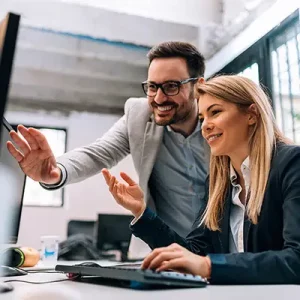 Ein Bild mit einem freundlich guckendem Mann und einer Frau im Büro.