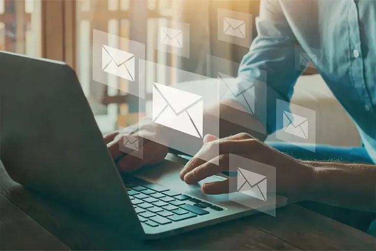 Ein Bild mit einem Laptop, auf dessen Tastatur Finger gerade eine Email schreiben.