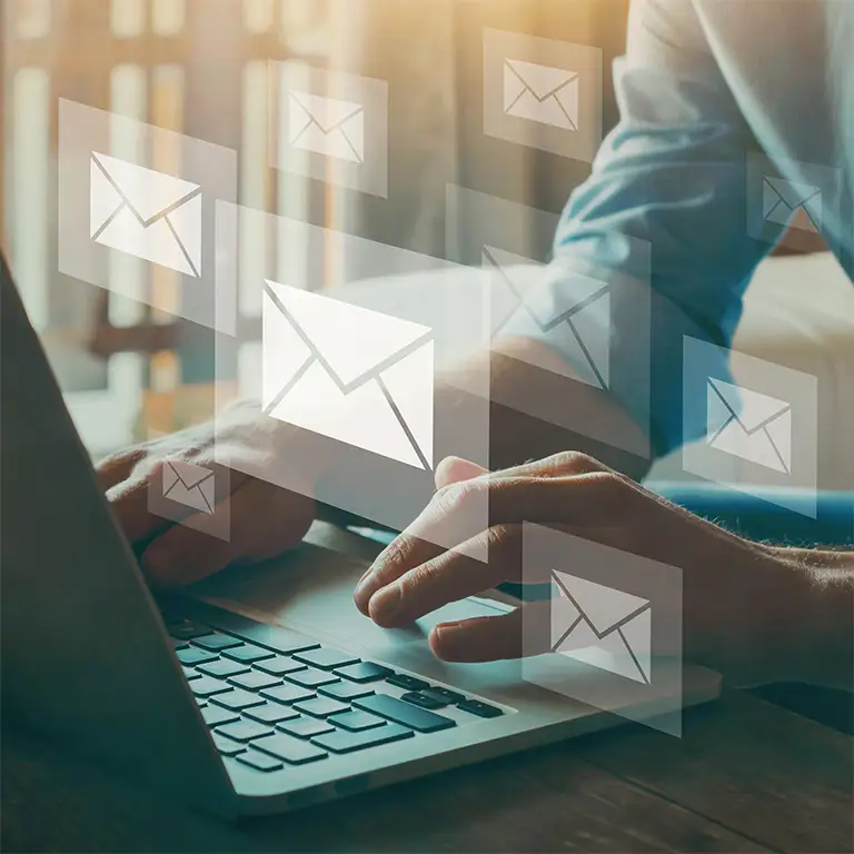 Hände auf einer Tastatur schreiben eine Email.